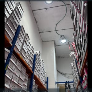 תאורה וחוטי חשמל במחסן עם מדפים גבוהים