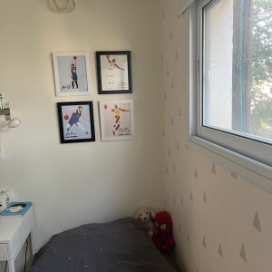 חדר שינה עם מזגן ותמונות על הקיר