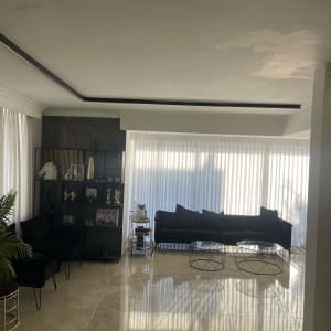 סלון עם ספה, שולחנות זכוכית ווילונות לבנים