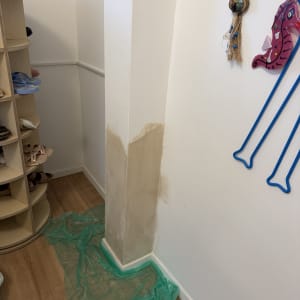 קיר עם תיקון צבע ויריעת פלסטיק ירוקה על הרצפה