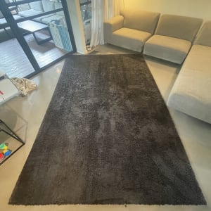 שטיח כהה על רצפה ליד ספה בהירה