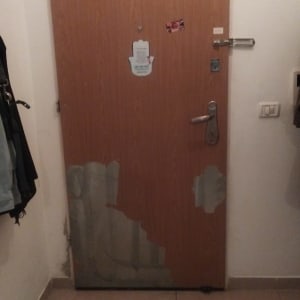 דלת עם ציפוי מתקלף בחלק התחתון