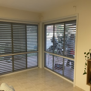 חלונות עם תריסי אלומיניום אפורים בחדר פנימי