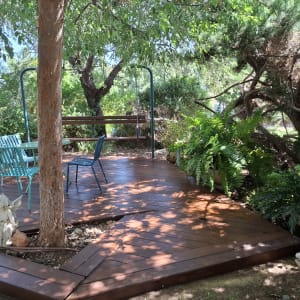 פינת ישיבה מעץ עם כיסאות ושולחן בגינה