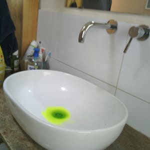 כיור עם ברז ומוצרי ניקוי על השיש