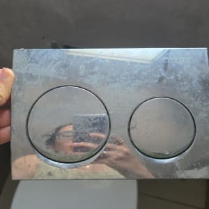לחצן הדחה כפול בשירותים עם השתקפות