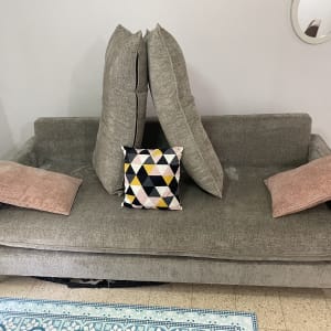 ספה אפורה עם כריות צבעוניות לניקוי