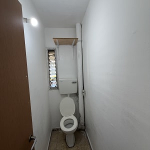 חדר שירותים קטן עם קירות ותקרה צבועים מחדש בלבן