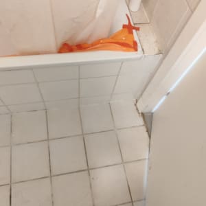 רצפת אריחים עם מגפיים, אמבטיה עם יריעת פלסטיק כתומה