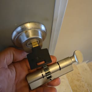 יד מחזיקה צילינדר ומפתח ליד דלת