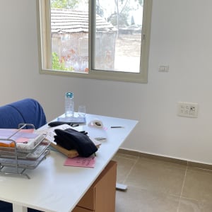 חדר מרוהט בעל קירות צבועים בלבן נקי וחלון אלומיניום