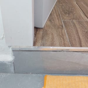 רצפת עץ ליד דלת עם סימני רטיבות על הקיר