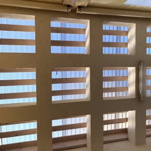 קיר עם חלונות עץ ומחיצות פלסטיק שקופות