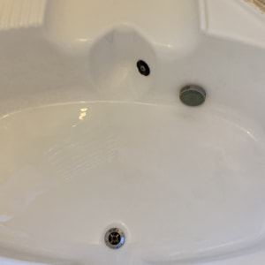 אמבטיה לבנה עם סימני לכלוך סביב הברז