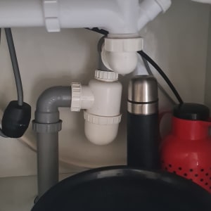 צנרת מתחת לכיור עם מחברים וכלים