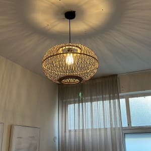 מנורה תלויה עם אור דולק בחדר עם וילון וסולם