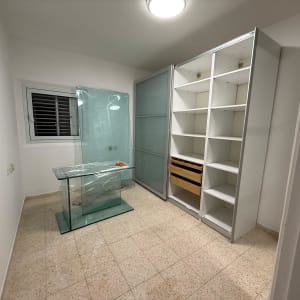 חדר עם ארון מדפים ודלתות זכוכית
