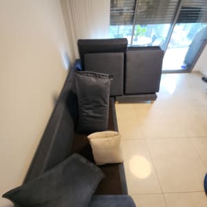 ספה אפורה עם כריות על רצפה מבריקה