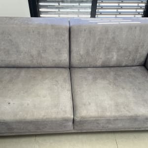 ספה אפורה עם כתם קטן על המושב