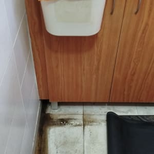 רצפה עם סימני רטיבות ליד ארון מטבח