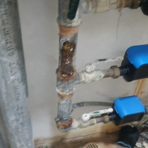 צינורות חלודים ושסתומים כחולים בעבודת אינסטלציה