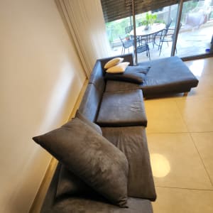 ספה אפורה עם כריות על רצפת אריחים