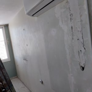 קיר עם תיקוני טיח וכתמי צבע