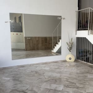 מראה גדולה על קיר לבן עם השתקפות מדרגות