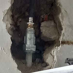 צינור מים בקיר עם חור