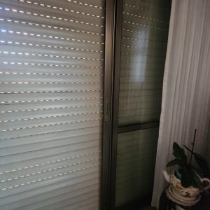 תריסים סגורים ליד חלון עם וילון