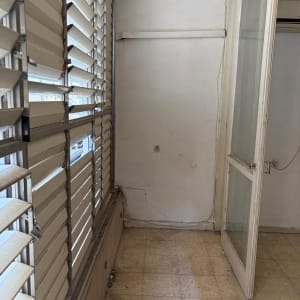 חדר ריק עם חלון ודלת זכוכית פתוחה