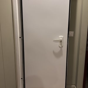 דלת לבנה עם ידית על רצפת עץ