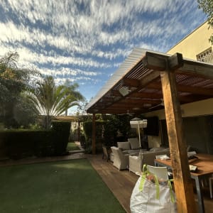 פרגולה מעץ עם ריהוט גן ודשא סינתטי