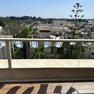 מעקה זכוכית עם דגלי ישראל תלויים עליו