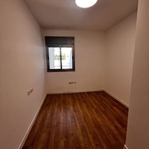 חדר ריק עם רצפת עץ ותאורה עליונה