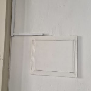 תעלת כבלים לבנה על קיר לבן ליד דלת