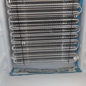 סלילי קירור מתכתיים בתוך מקרר עם חוטים