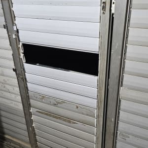 תריסים לבנים עם שלב שבור וחור גדול