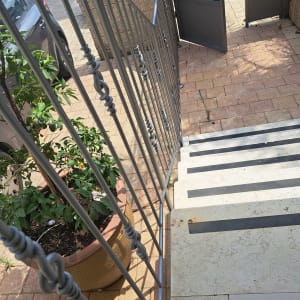 מעקה מתכת צבוע בצבע אפור על מדרגות