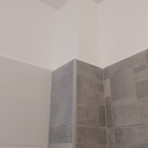 פינת קיר צבועה עם אריחים אפורים ולבנים