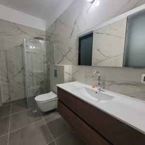 חדר אמבטיה נקי עם כיור ומקלחון