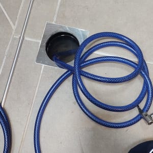 צינור כחול מחובר לניקוז ברצפה