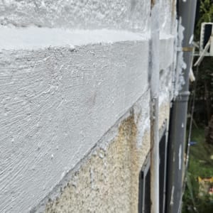 קיר עם איטום לבן על גבי טיח חיצוני