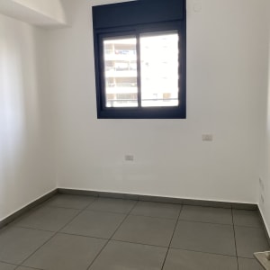 חדר ריק עם רצפת אריחים נקייה וחלון