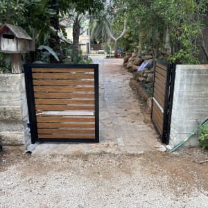 שער אלומיניום בכניסה לגינה עם שביל מרוצף