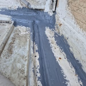 איטום עם חומר אפור על משטח בטון