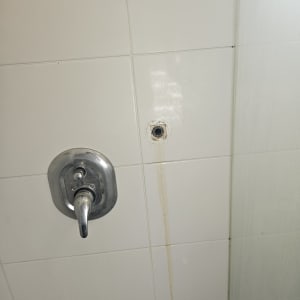 ברז מקלחת על קיר אריחים לבנים