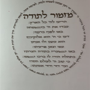 כתובת בעברית על קיר לבן עם עיטורים
