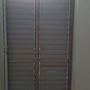 תריסים סגורים על חלון עם אור שמש