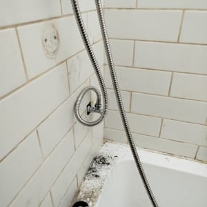 אמבטיה עם צינור מים ותיקון קיר
